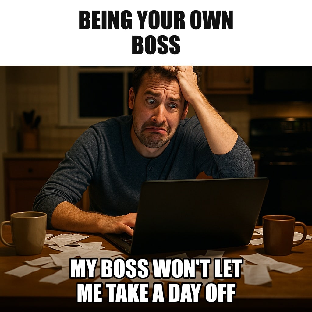 A man working alone at a kitchen table at midnight with a laptop, coffee mugs and receipts everywhere, his dog asleep at his feet. Caption: "Being your own boss My boss won't let me take a day off"