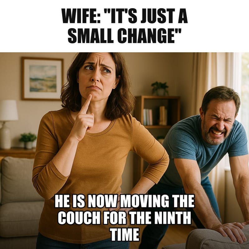 A husband straining to push a heavy sofa across a living room while his wife stands in the middle of the room with her head tilted, considering. Caption: "Wife: "It's just a small change" He is now moving the couch for the ninth time"