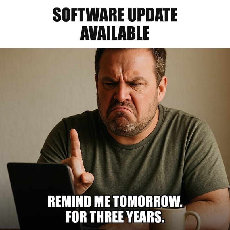 A man sitting at his laptop with a firm, dismissive expression, finger raised to tap, a coffee mug beside him and dust on the laptop's edges. Caption: "Software update available Remind me tomorrow. For three years."