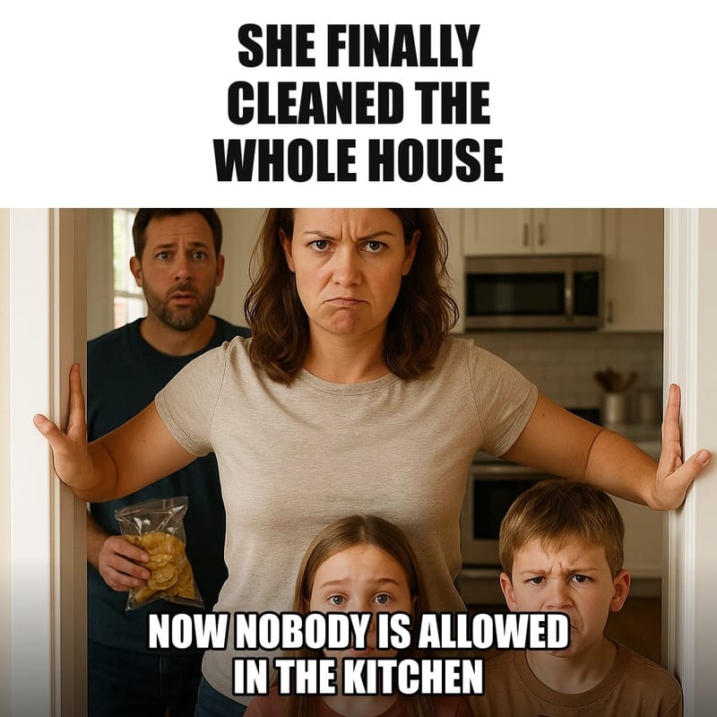 A woman standing guard in a spotless gleaming kitchen doorway with arms spread across it, blocking her husband and kids who are holding snacks. Caption: "She finally cleaned the whole house Now nobody is allowed in the kitchen"
